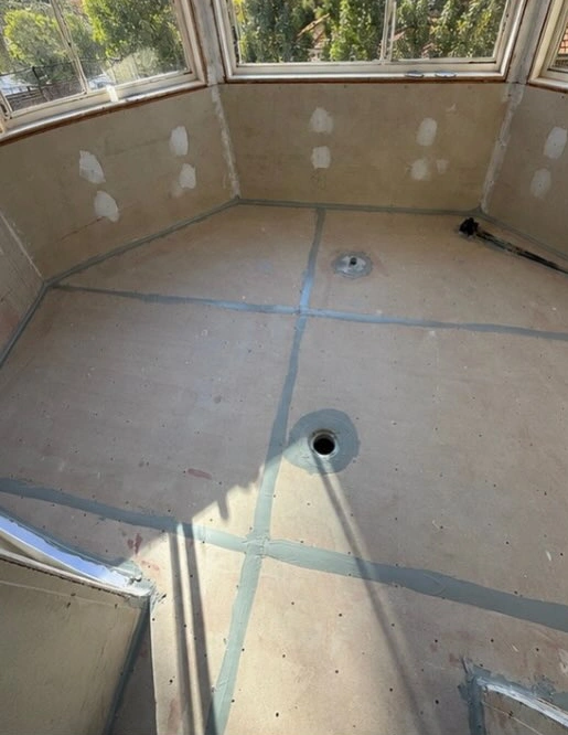 Prepared wet-area floor and sealed board joints beneath bay windows